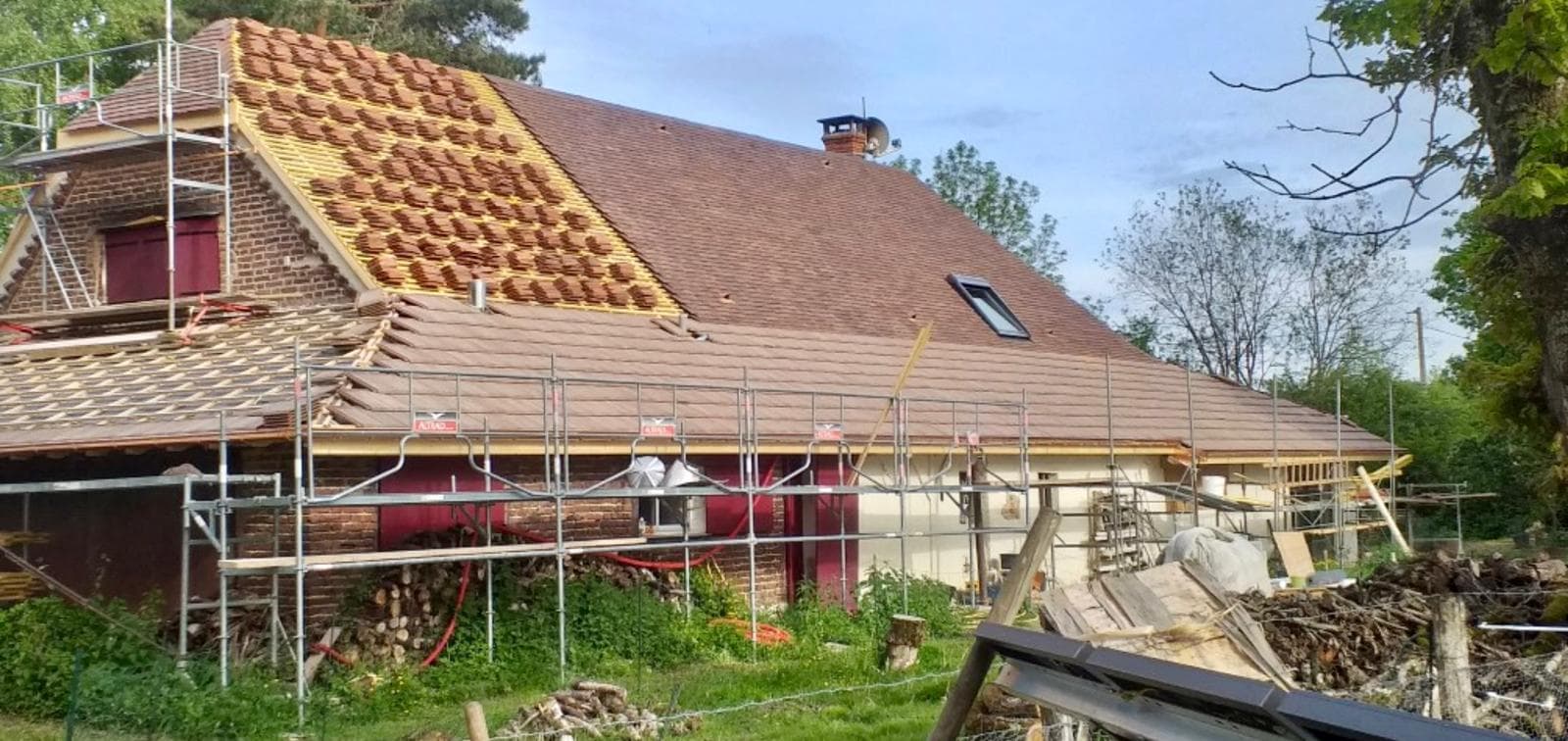 Rénovation de toiture à moitié réalisée à Villemandeur par JCD Rénovation : ancienne couverture d'un côté, tuiles neuves de l'autre